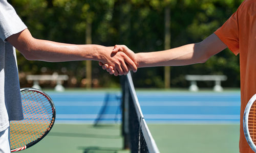 Midsection of man playing tennis