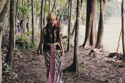 Full length portrait of man standing in forest