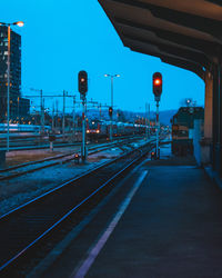 Illuminated railroad station platform against clear sky