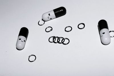 High angel view of capsules and rings on white background