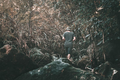 Man standing by tree in forest