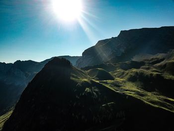 Scenic view of mountains against sky on sunny day