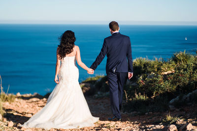 Rear view of couple holding hands