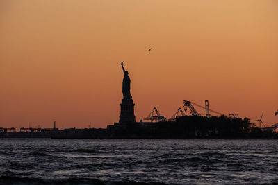Silhouette of statue of sea during sunset