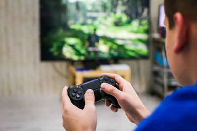 Close-up of man playing video game at home