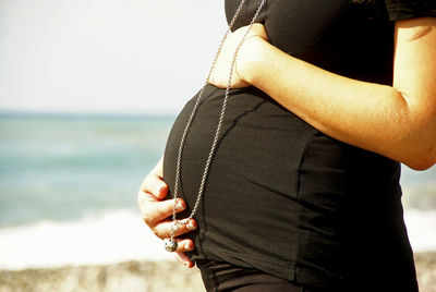 Midsection of person standing on beach