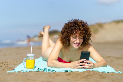 Young woman using mobile phone at beach