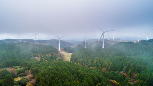 Windmills on field against sky