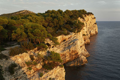 Rock formations by sea against sky