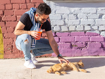 Full length of a man with dog against wall