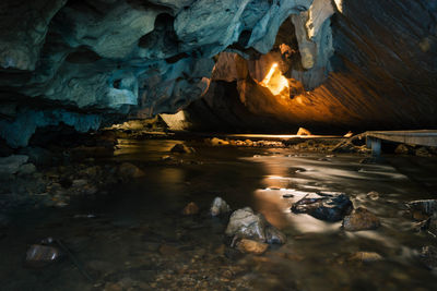 Water flowing amidst rock formations in cave