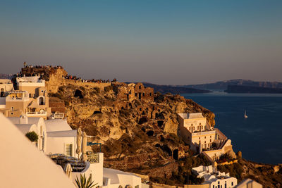 Tourists looking at the amazingly beautiful sunset at la caldera in oia city in santorini island