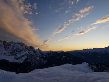 Scenic view of snow covered mountains against sky during sunset