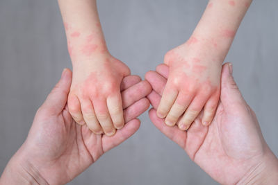 Cropped image of mother holding kids hands