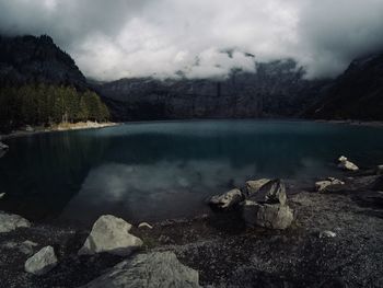 Scenic view of lake by mountain against sky