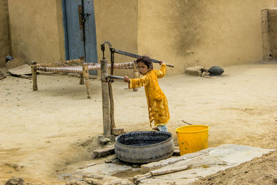 Side view of a boy working on metal structure