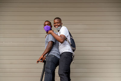 Two afro young men in electric kick scooter outdoors