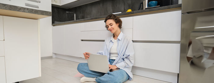 Portrait of young woman sitting on sofa at home