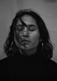 Close-up portrait of woman against wall