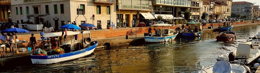 Boats moored in canal along buildings