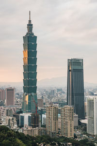 Modern buildings in city against cloudy sky