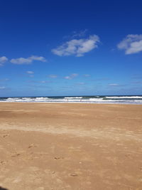 Scenic view of beach against blue sky