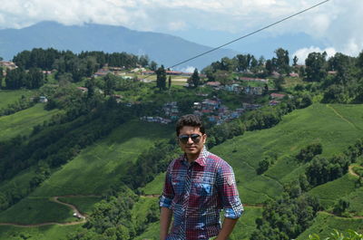 Portrait of young man standing on landscape