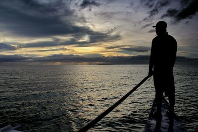 Rear view of man sailing boat during sunrise