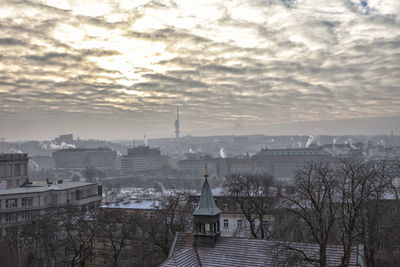 Cityscape against cloudy sky