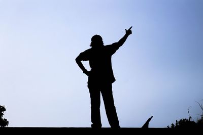 Low angle view of silhouette man standing against clear sky