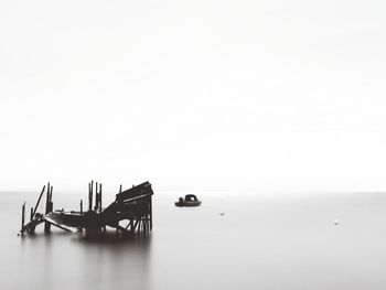 Scenic view of sea against clear sky with the remains of an old wooden dock