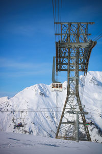 Snow covered mountain against sky and cable car