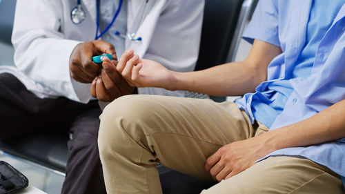 Midsection of doctor examining patient in hospital