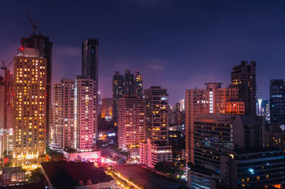 Illuminated cityscape against sky at night