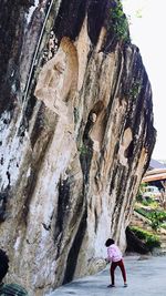 Rear view of woman standing on rock formation