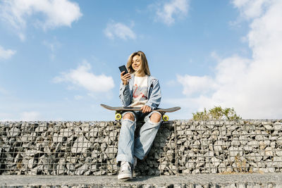 Low angle view of woman sitting against the wall
