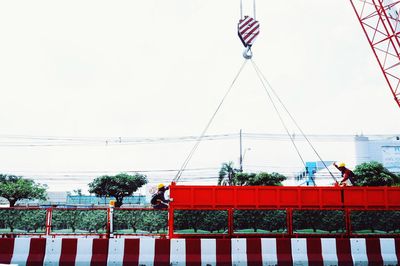 Low angle view of men standing against clear sky