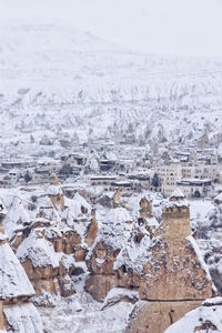 High angle view of rock formations and buildings during winter at goreme