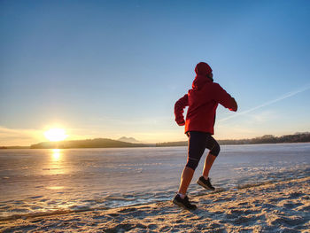 Woman or girl run in winter river park by evening. happy face of running woman within training run