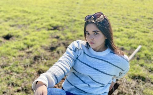 Portrait of beautiful young woman lying on land