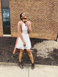 Full length of young woman standing against wall