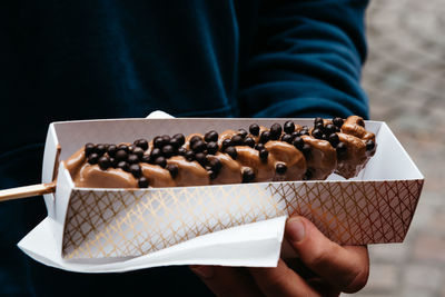 Midsection of person holding dessert