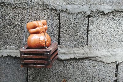 Close-up of person hand on cutting board against wall