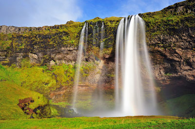 Scenic view of waterfall against sky