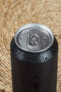 Black aluminum can, with drops of water.