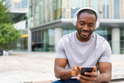 Young man using mobile phone in city