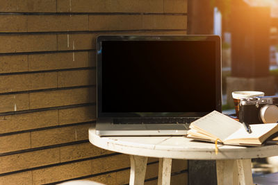 Close-up of laptop with blank screen at sidewalk cafe