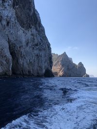 Rock formation in sea against sky