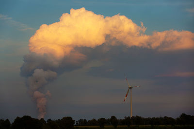 Low angle view of wind turbine against sky during sunset