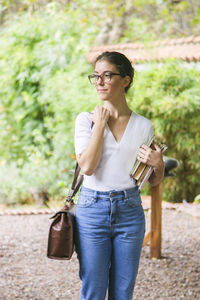 Young woman looking away while standing outdoors